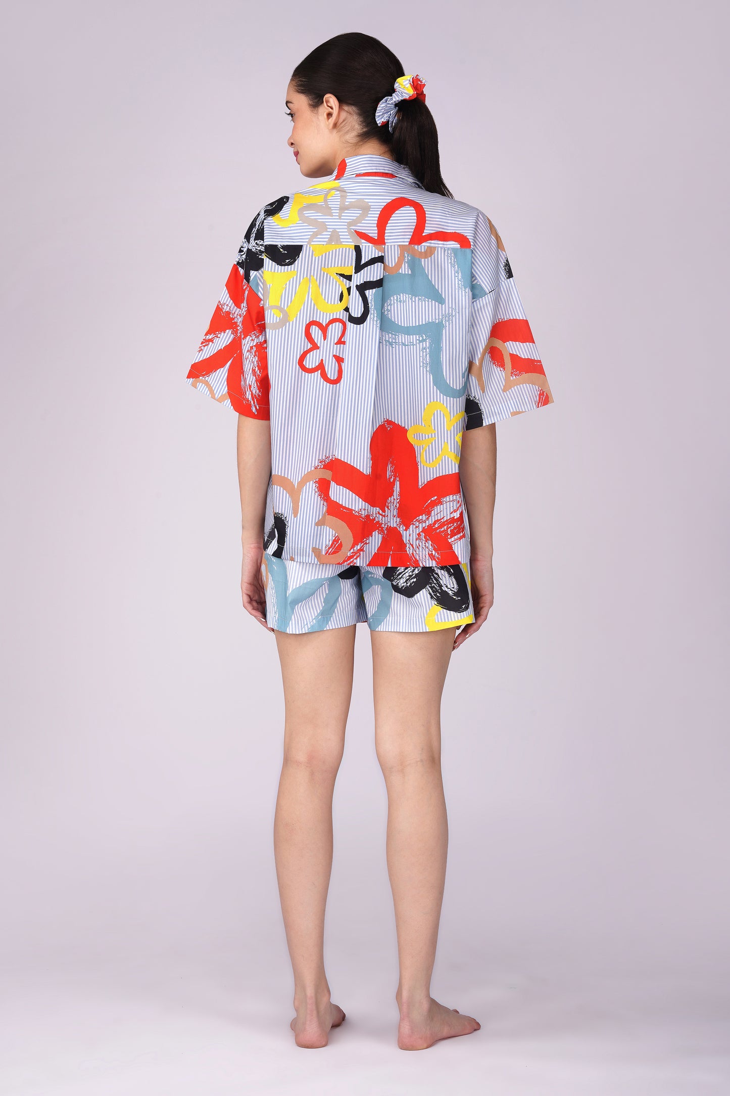 Back view of a woman wearing a vibrant Pop Art Flowers Shorts Set, featuring colorful designs, showcasing womens cotton shorts set for lounging.