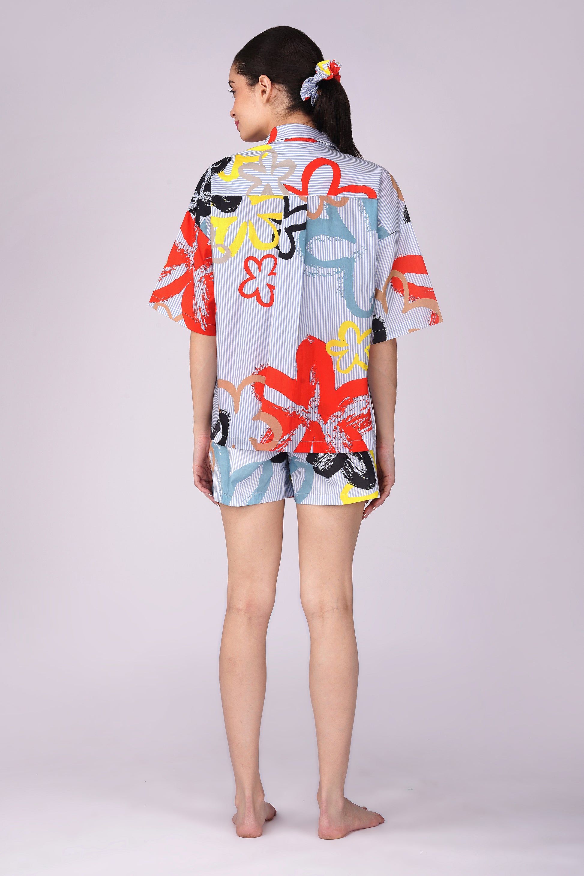 Back view of a woman wearing a vibrant Pop Art Flowers Shorts Set, featuring colorful designs, showcasing womens cotton shorts set for lounging.